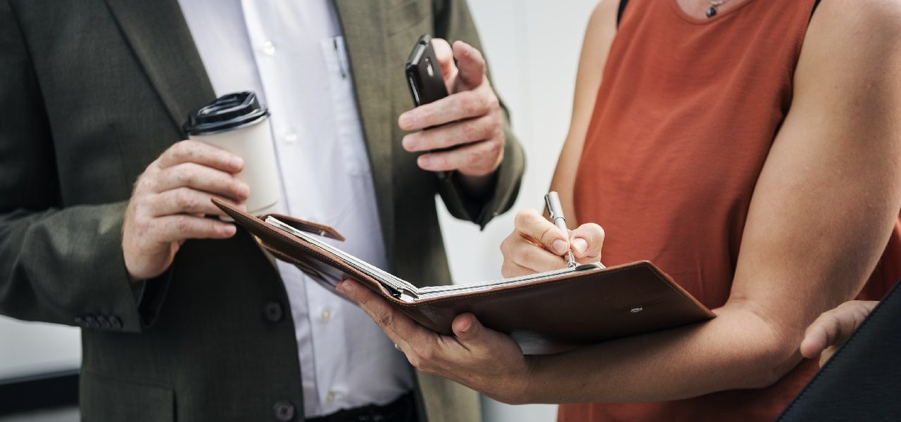 man explaining contract to woman signing papers